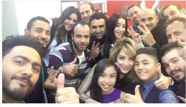 تامر حسني مع فريقه وتبدو زوجته بسمة بوسيل في الصورة