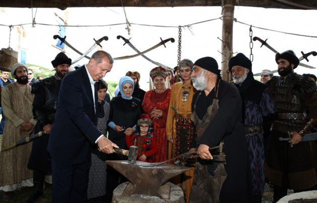 اردوغان وزوجته وخلفهما إنجين التان أو أرطغرل يطلعان على طريقة مؤدي شخصية ديلدمير صانع السيوف والمعدات الحربية  