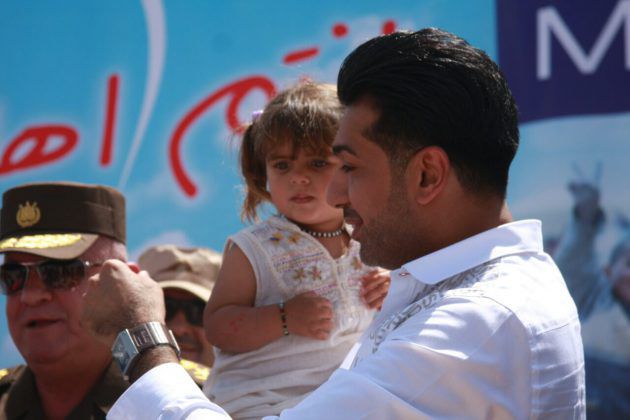همام إبراهيم يحمل طفلة صغيرة ويداعبها