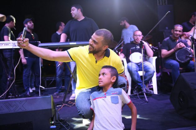 محمد رشاد وسلفي مع أحد معجبيه على المسرح