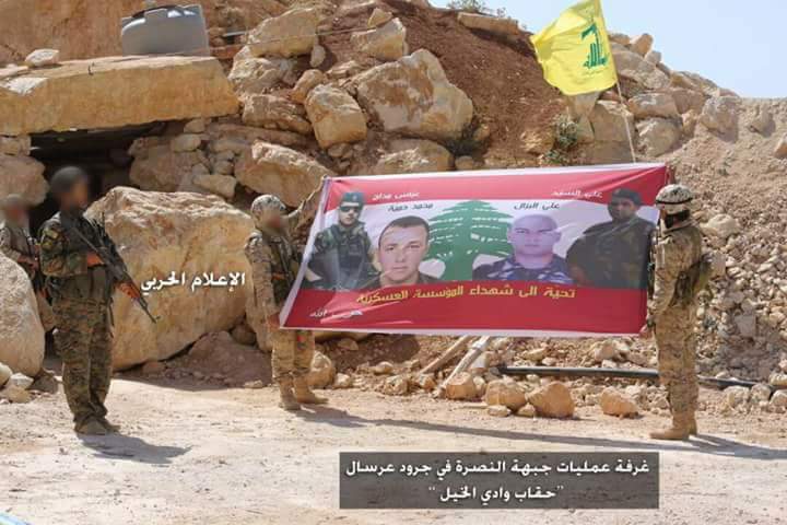 حزب الله يرفععناصر من حزب الله يرفعون صورة شهداء الجيش اللبناني