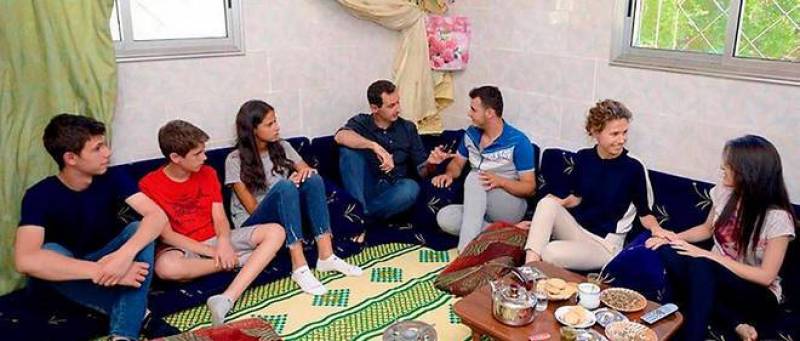 اسماء الأسد مع زوجها رئيس البلاد وولديها في زيارة لبيت سوري فقير